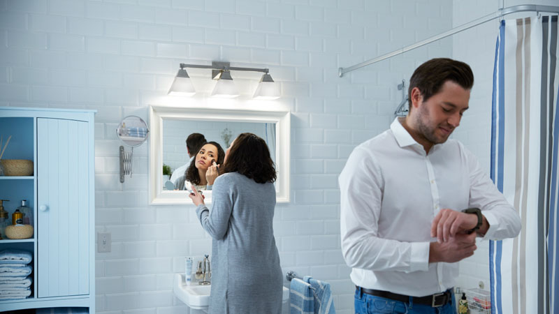 Žena a muž v osvětlené koupelně